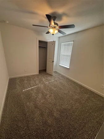 a view of a livingroom with a ceiling fan and window