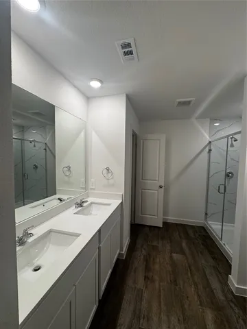 a spacious bathroom with a double vanity sink a mirror and a bathtub