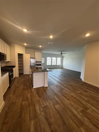 a large kitchen with stainless steel appliances granite countertop a large counter top a stove and a refrigerator