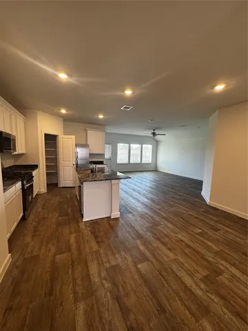 a large kitchen with stainless steel appliances granite countertop a large counter top a stove and a refrigerator