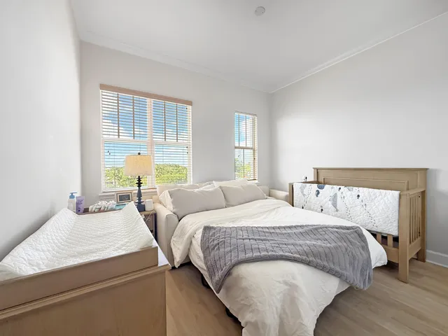 a bedroom with a bed and two window