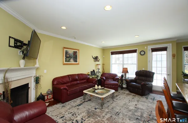 a living room with furniture a fireplace and a large window