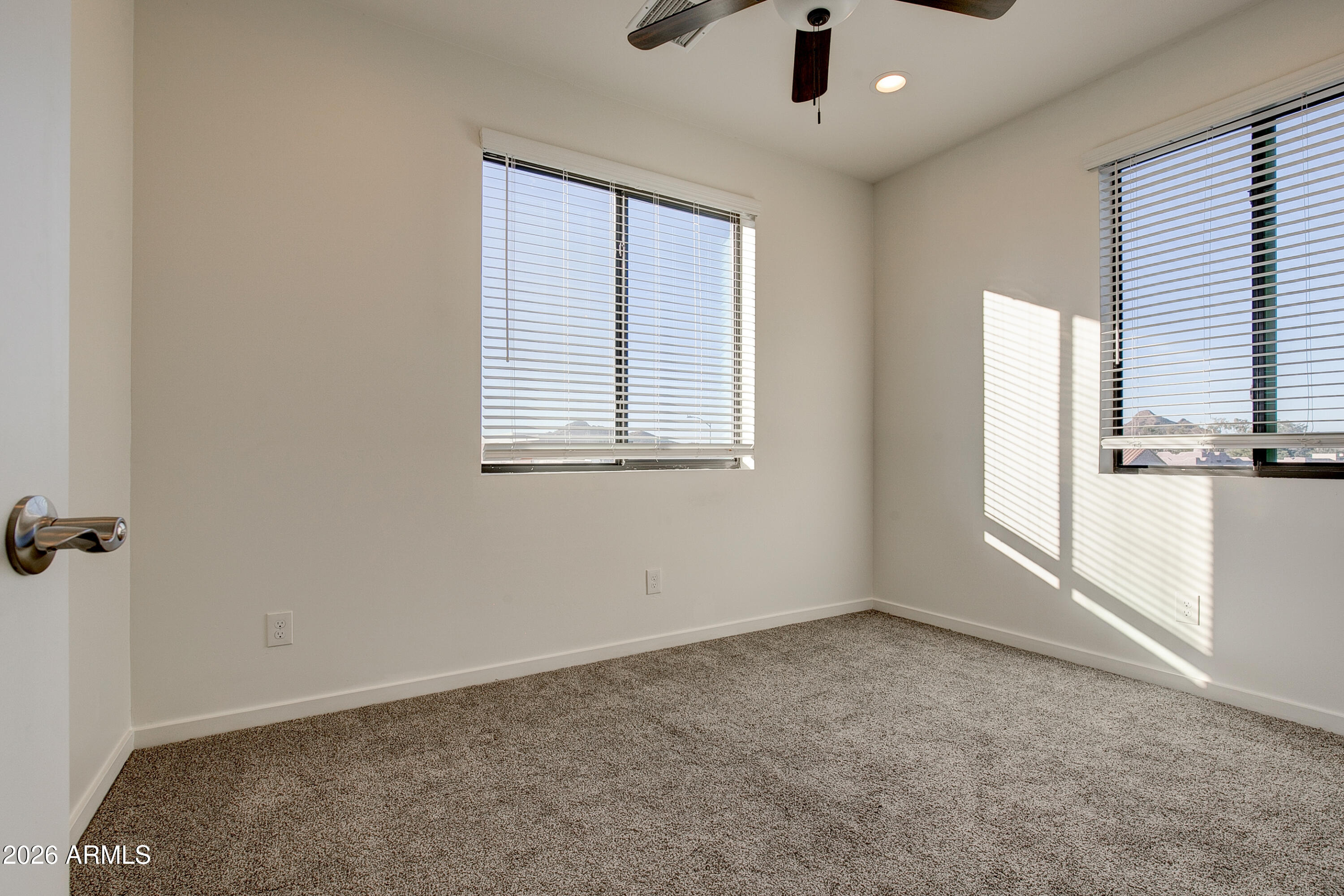 16075 North 30th Street Phoenix, AZ 85032 - Photo 26 of 41 an empty room with windows and chandelier fan