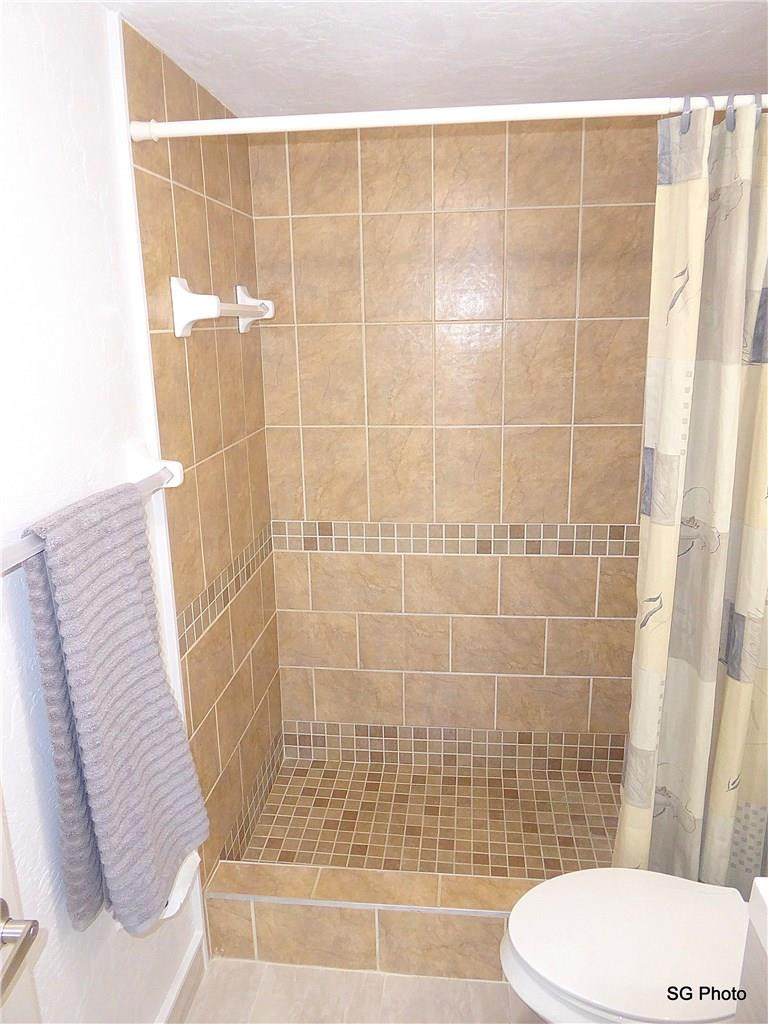 611 East Woolbright Road, Unit 407 Boynton Beach, FL 33435 - Photo 17 of 22 a bathroom with a toilet and shower
