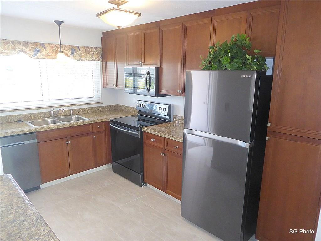 611 East Woolbright Road, Unit 407 Boynton Beach, FL 33435 - Photo 2 of 22 a kitchen with stainless steel appliances granite countertop a refrigerator a sink a stove a microwave and island