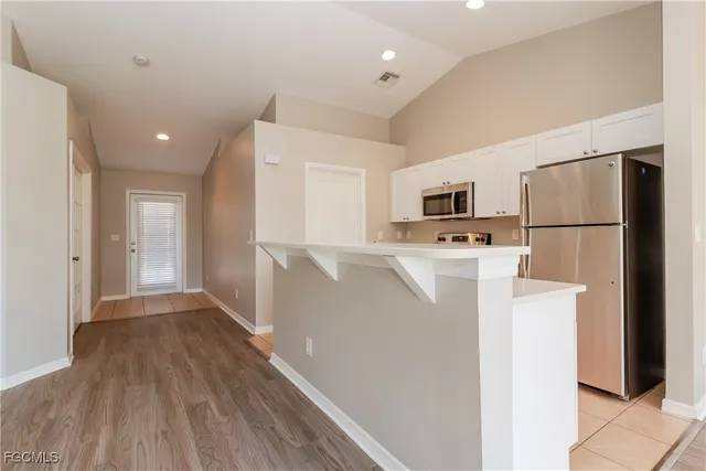 a view of kitchen with refrigerator stove and wooden cabinets