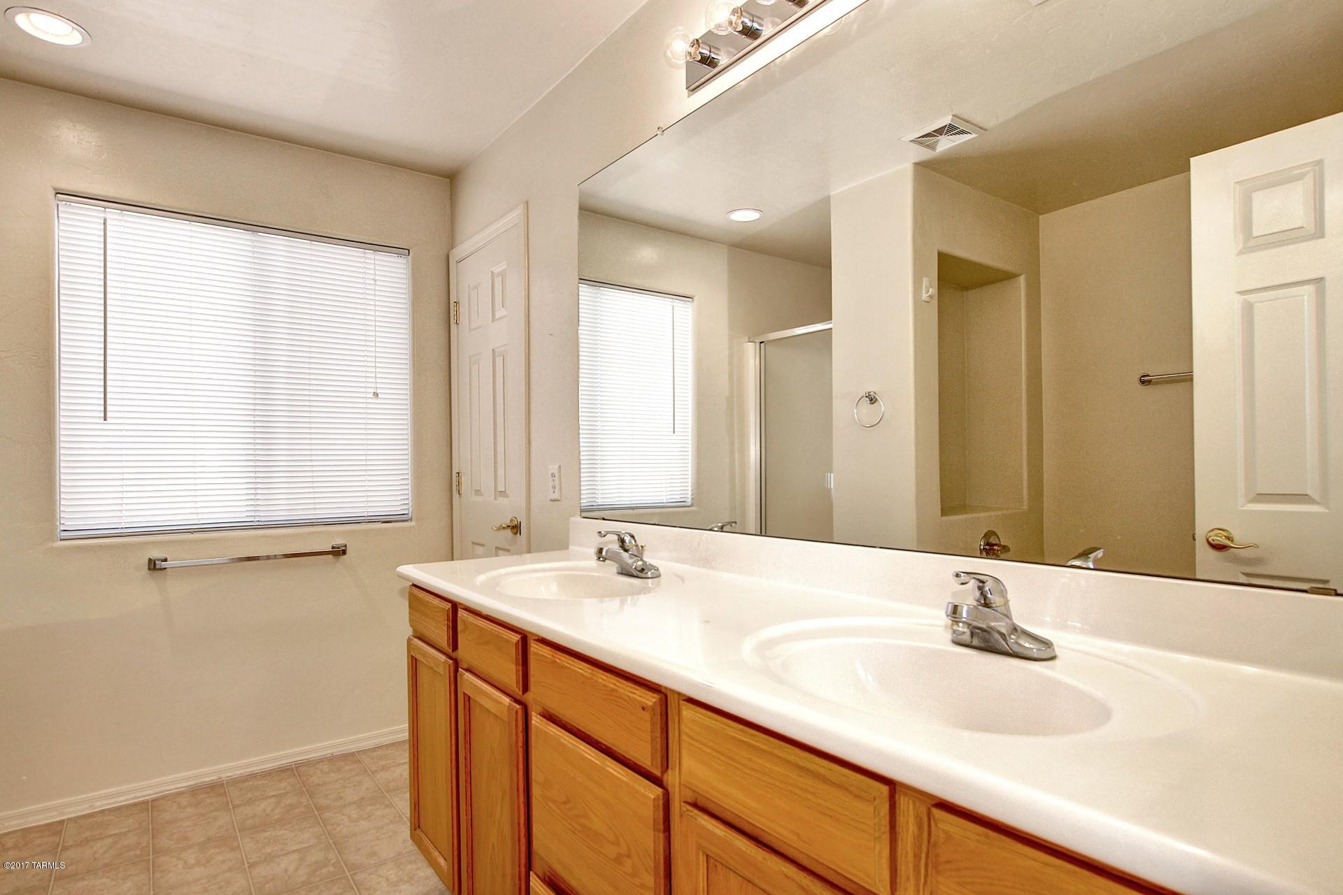 8350 East Bowline Road Tucson, AZ 85710 - Photo 14 of 26 a bathroom with double vanity sinks and a mirror