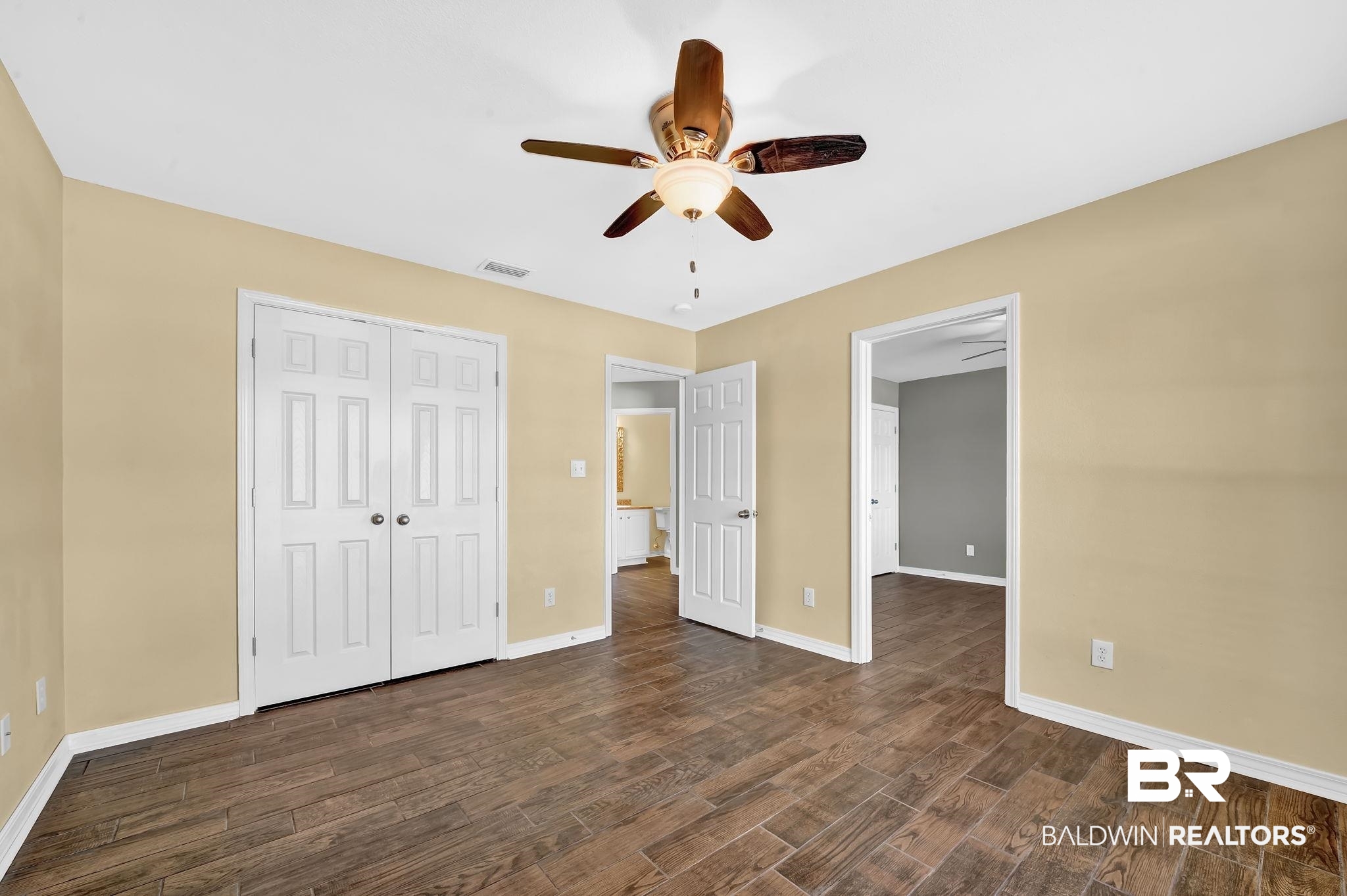 16444 Hamlet Lane Foley, AL 36535 - Photo 37 of 49 Unfurnished bedroom featuring a closet, a ceiling fan, dark wood finished floors, baseboards, and visible vents