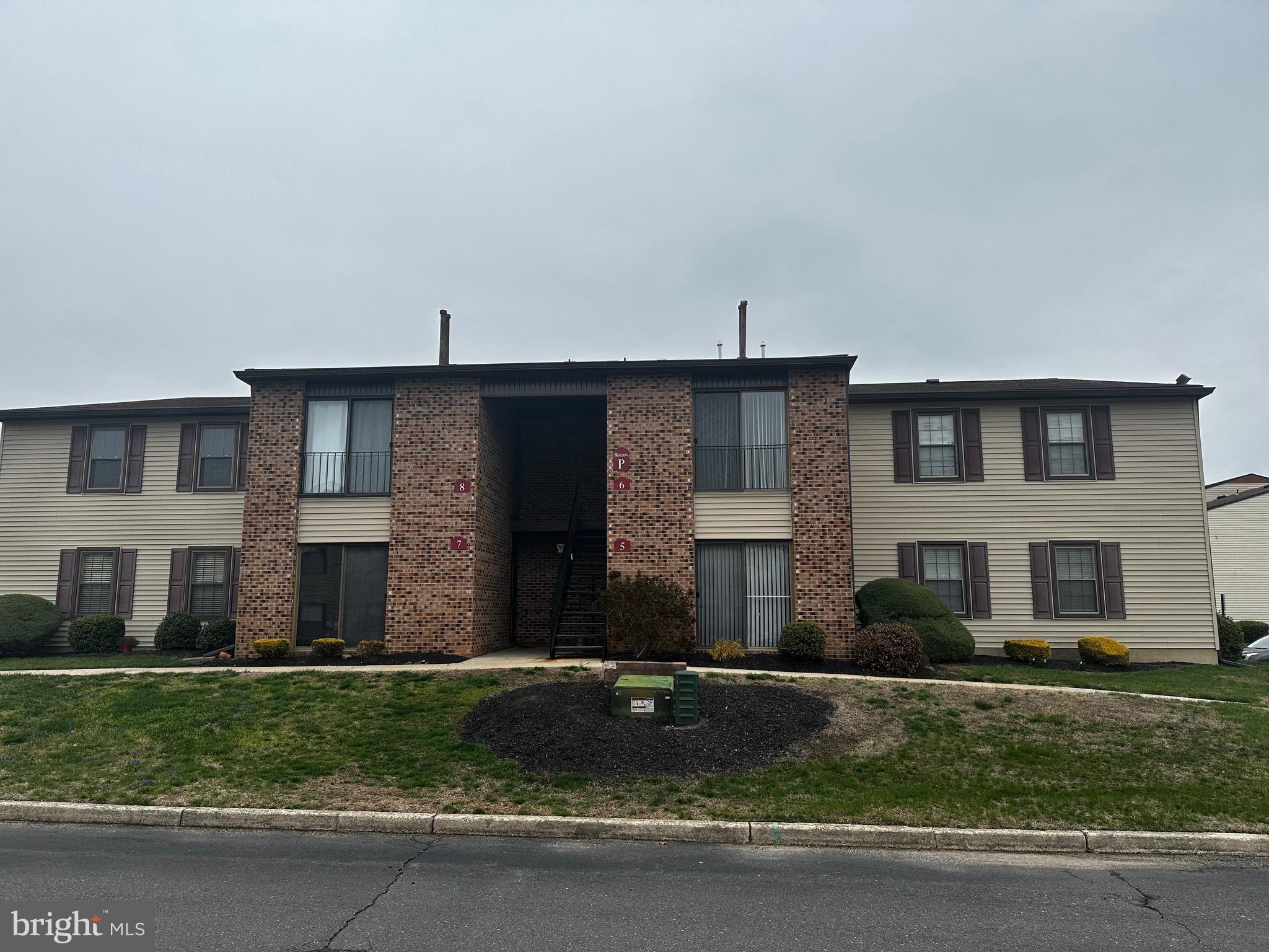 a view of a brick house next to a yard