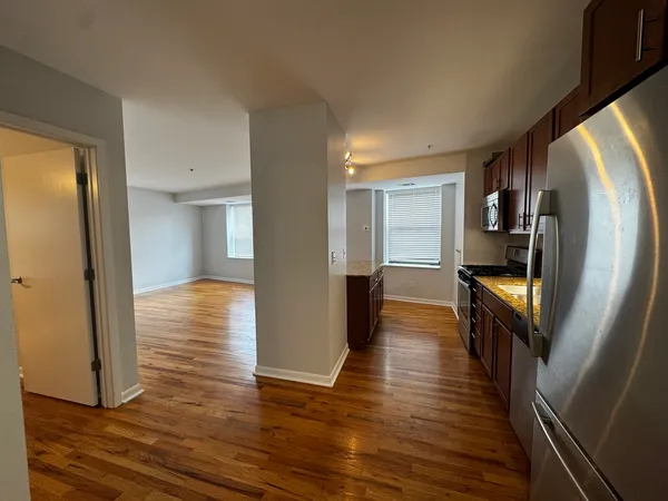 a view of a hallway with wooden floor and staircase