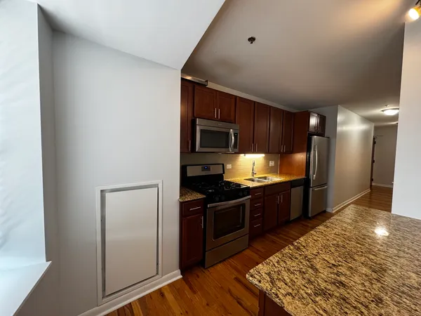 a kitchen with stainless steel appliances granite countertop a refrigerator and a stove top oven