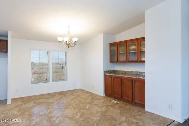 an empty room with chandelier and windows