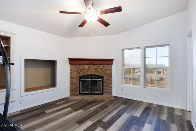 wooden floor fireplace and windows in an empty room