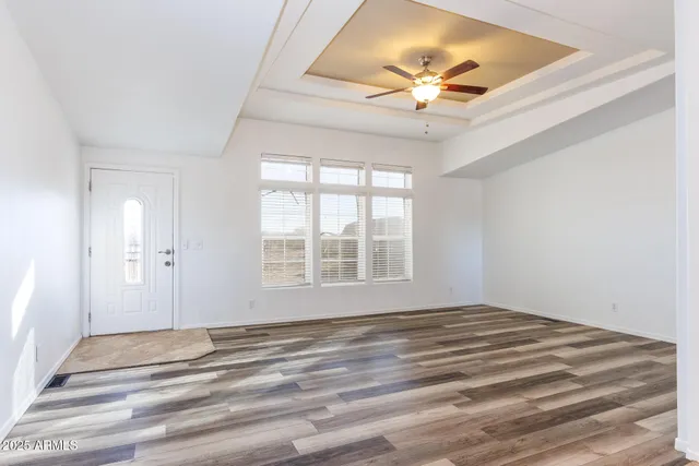 a view of an empty room with window and a ceiling fan