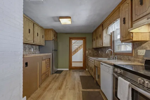 a kitchen with granite countertop a sink stove and cabinets