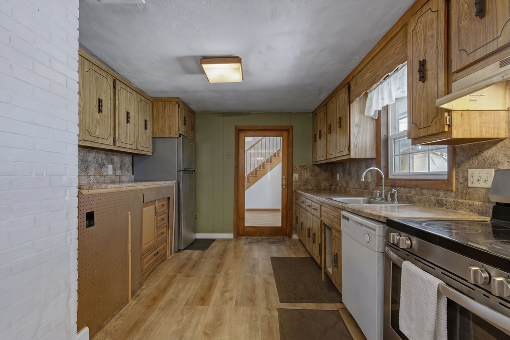 49 Francine Road Raynham, MA 02767 - Photo 5 of 31 a kitchen with granite countertop a sink stove and cabinets