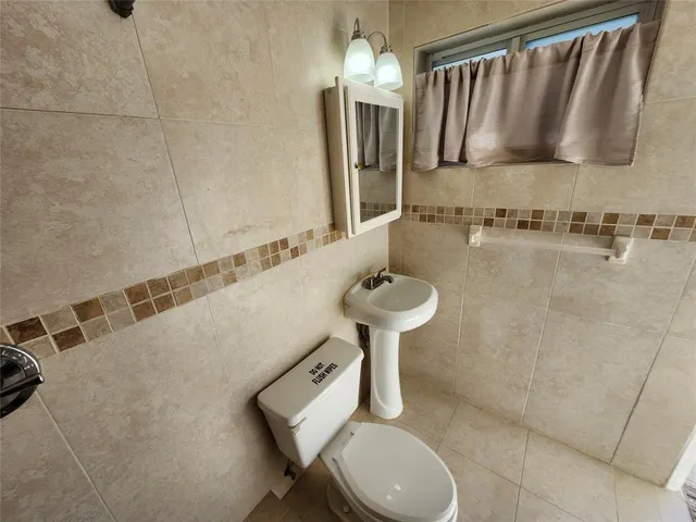 a bathroom with a sink toilet and a mirror