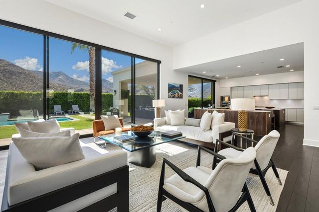 a living room with lots of furniture and view of kitchen