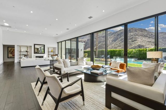 a kitchen with kitchen island a large counter top space a sink stainless steel appliances and a large window