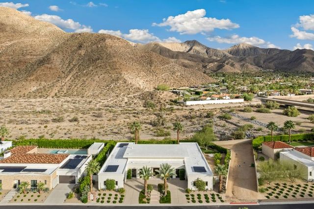 a living room with furniture kitchen view and a large window