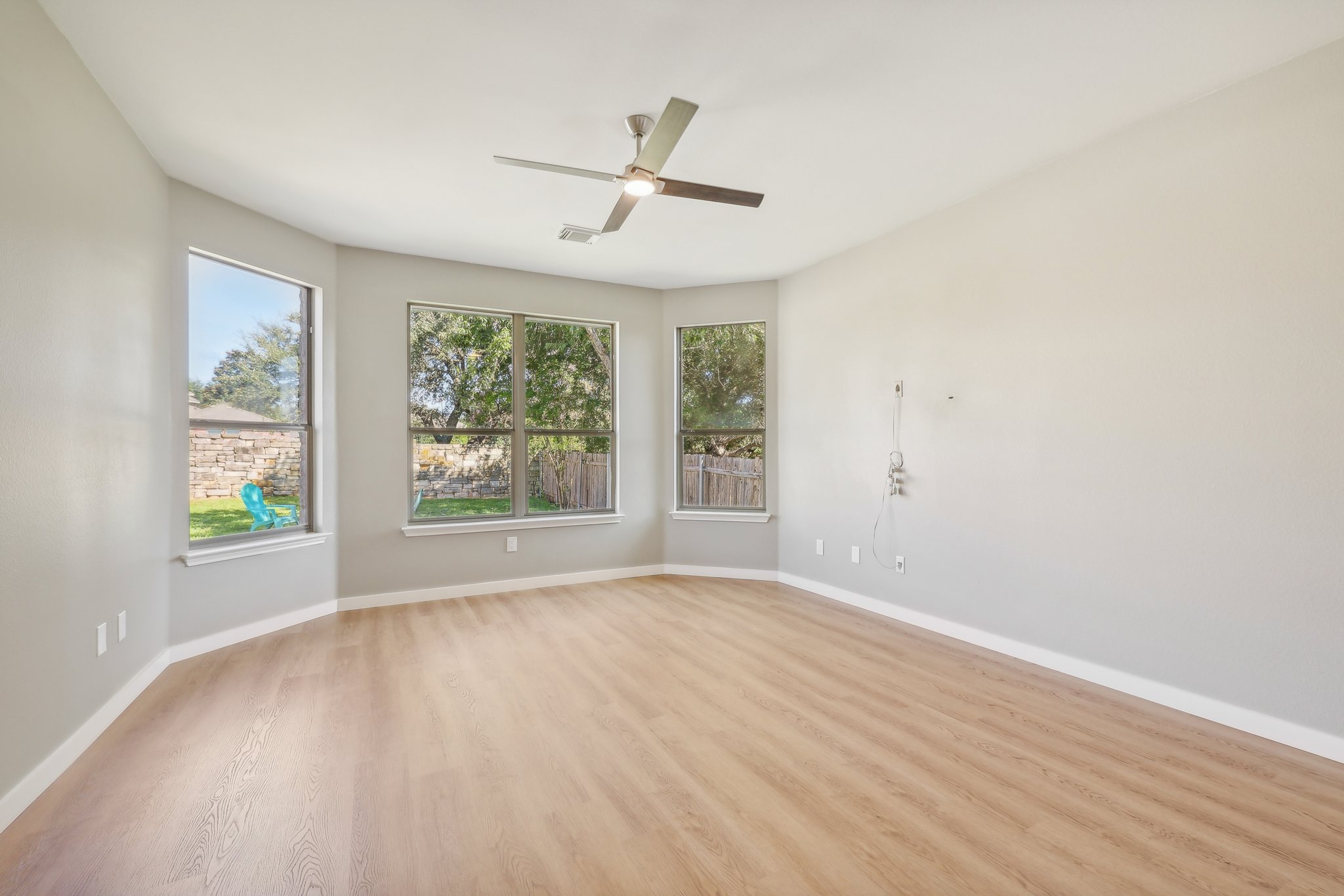 7324 Moon Rock Road Austin, TX 78739 - Photo 12 of 30 an empty room with wooden floor fan and windows