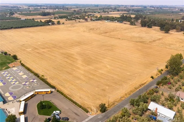 an aerial view of ocean and residential houses with outdoor space
