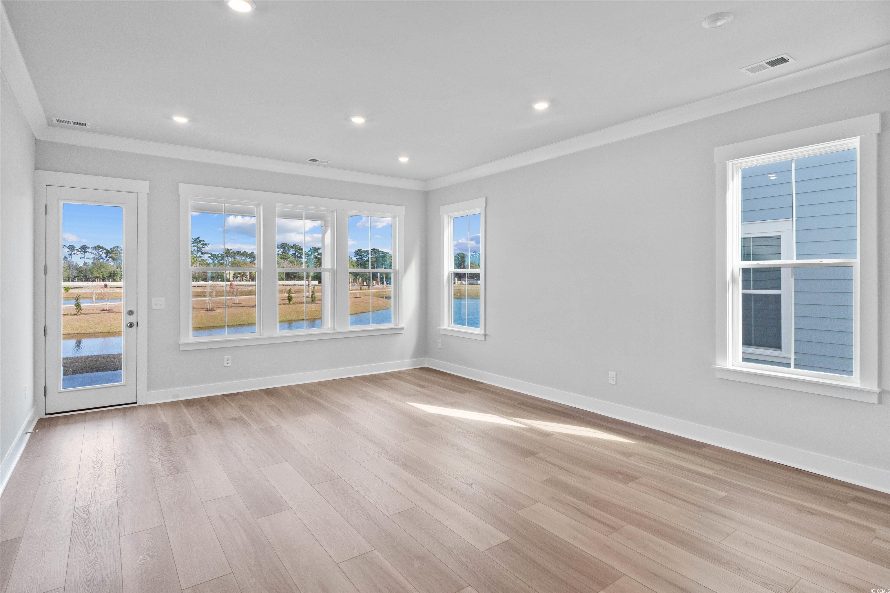 220 Atlantic Breeze Street Myrtle Beach, SC 29572 - Photo 17 of 38 Empty room featuring light wood-style floors, a water view, crown molding, and recessed lighting