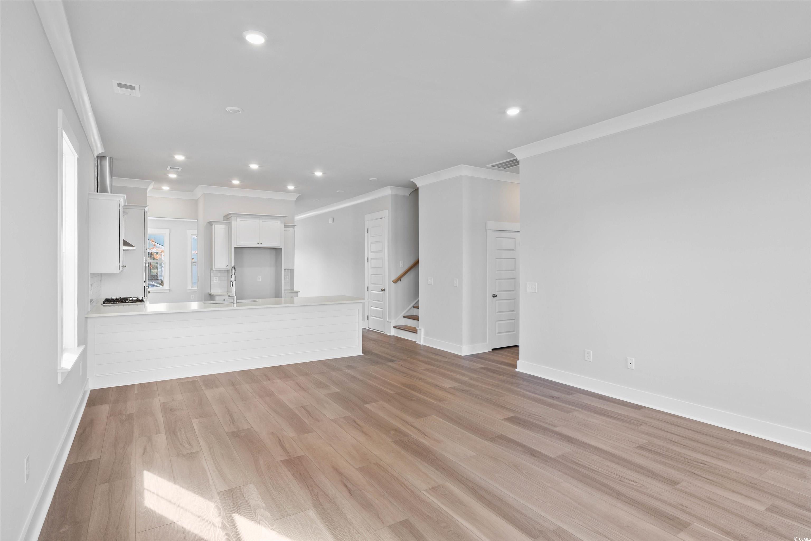 220 Atlantic Breeze Street Myrtle Beach, SC 29572 - Photo 18 of 38 Unfurnished living room with recessed lighting, light wood-style floors, ornamental molding, and stairway