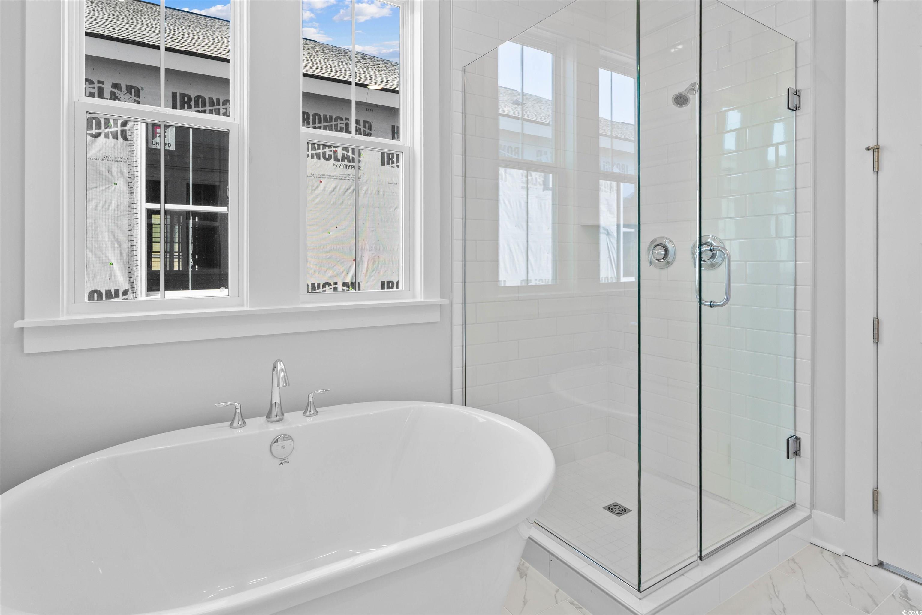 220 Atlantic Breeze Street Myrtle Beach, SC 29572 - Photo 22 of 38 Full bathroom featuring healthy amount of natural light, marble look tile flooring, a freestanding tub, and a shower stall