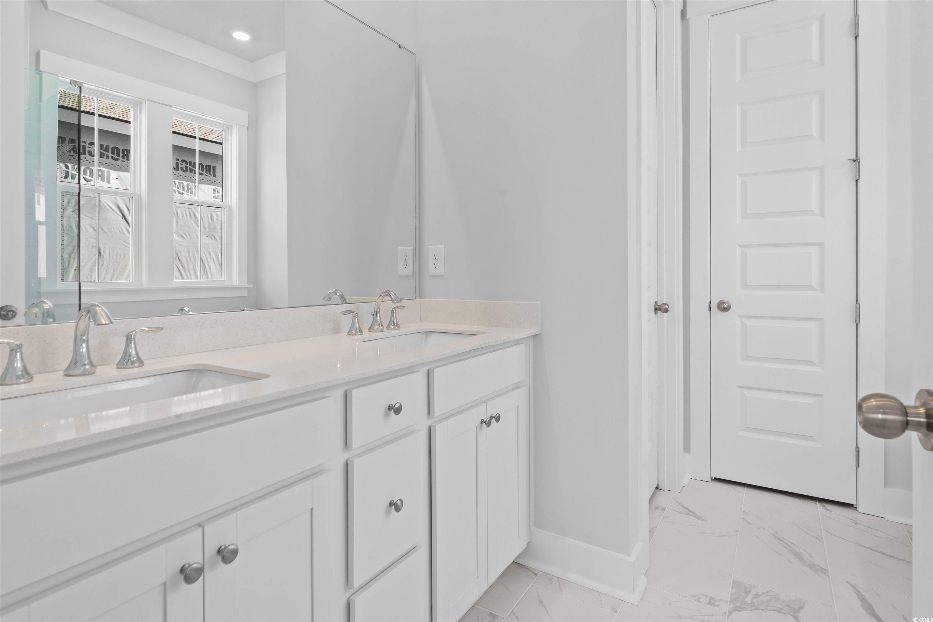 220 Atlantic Breeze Street Myrtle Beach, SC 29572 - Photo 23 of 38 Bathroom with double vanity and light marble finish flooring