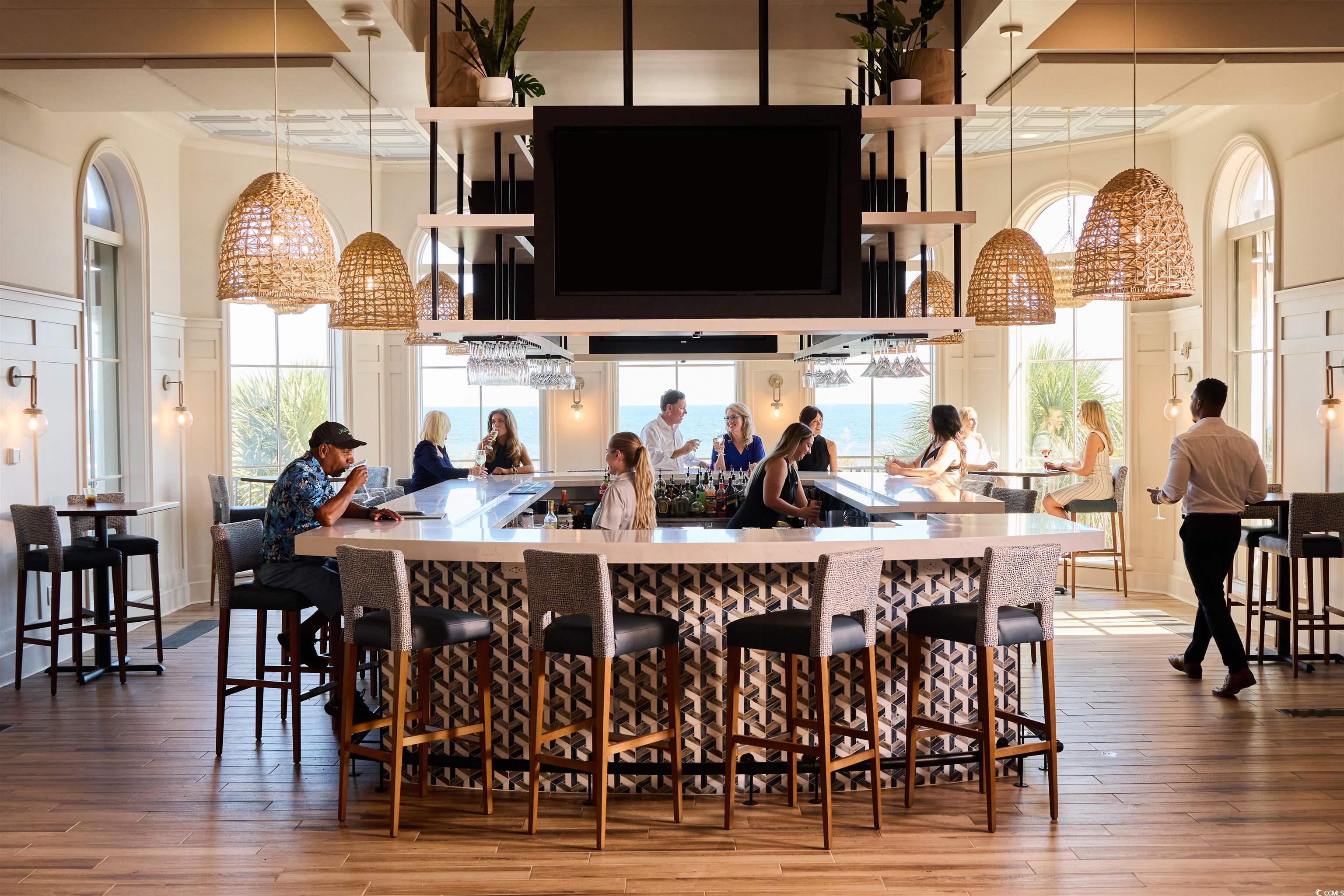 220 Atlantic Breeze Street Myrtle Beach, SC 29572 - Photo 35 of 38 Bar area featuring hardwood / wood-style floors, a towering ceiling, hanging light fixtures, and coffered ceiling