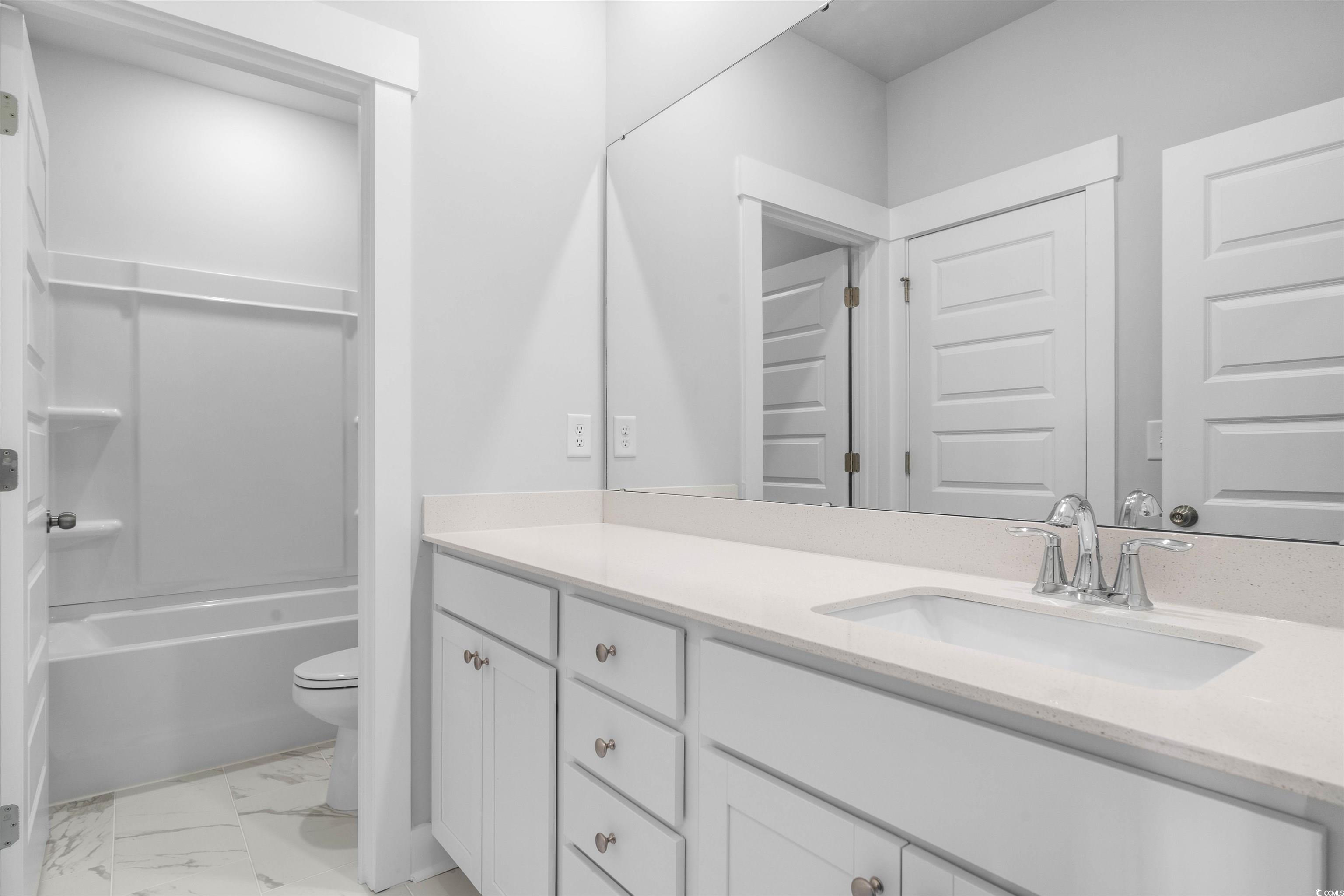 220 Atlantic Breeze Street Myrtle Beach, SC 29572 - Photo 5 of 38 Full bath with vanity, light marble finish floors, and shower / tub combination