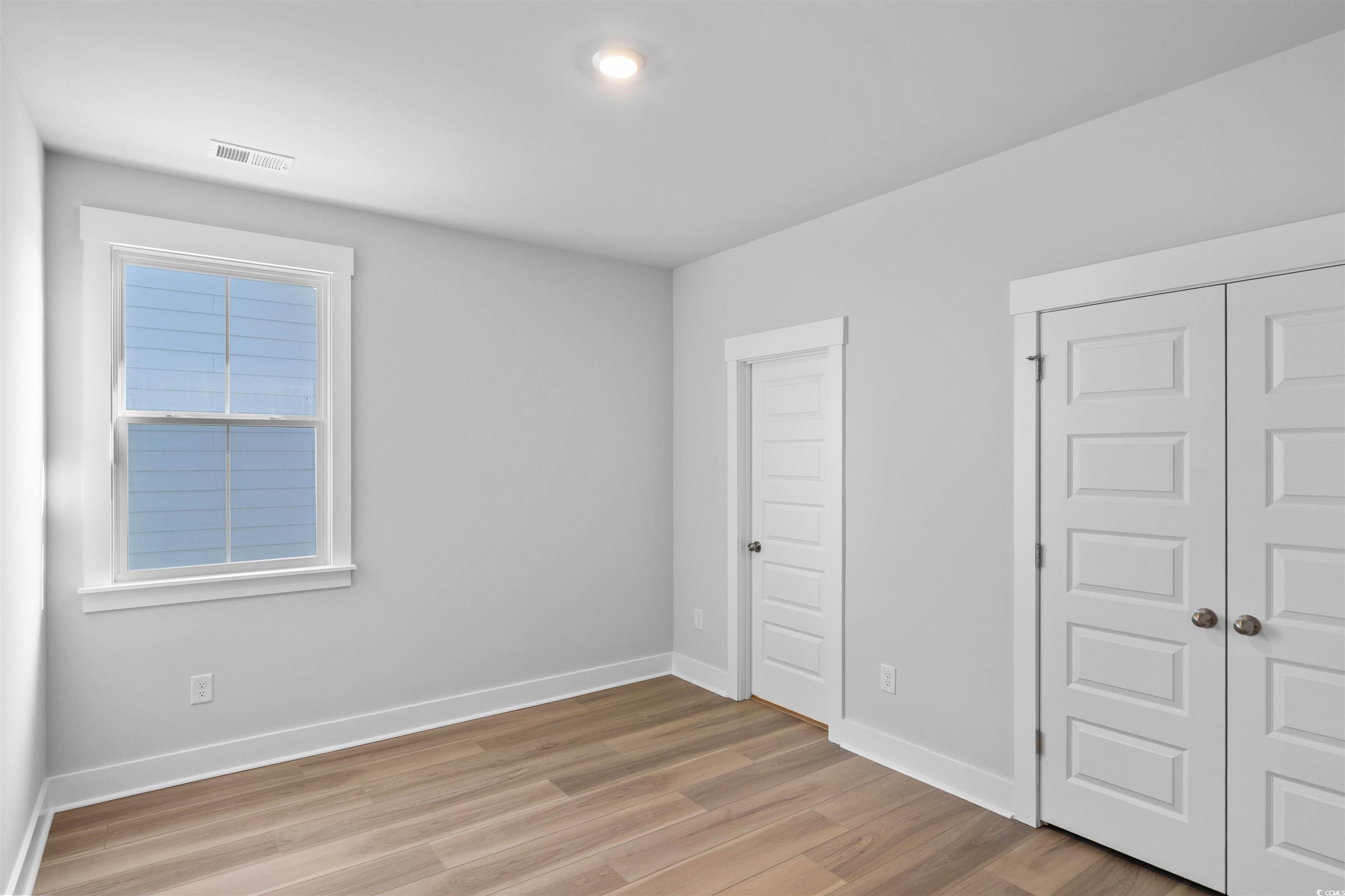 220 Atlantic Breeze Street Myrtle Beach, SC 29572 - Photo 8 of 38 Unfurnished bedroom with light wood-style floors and a closet