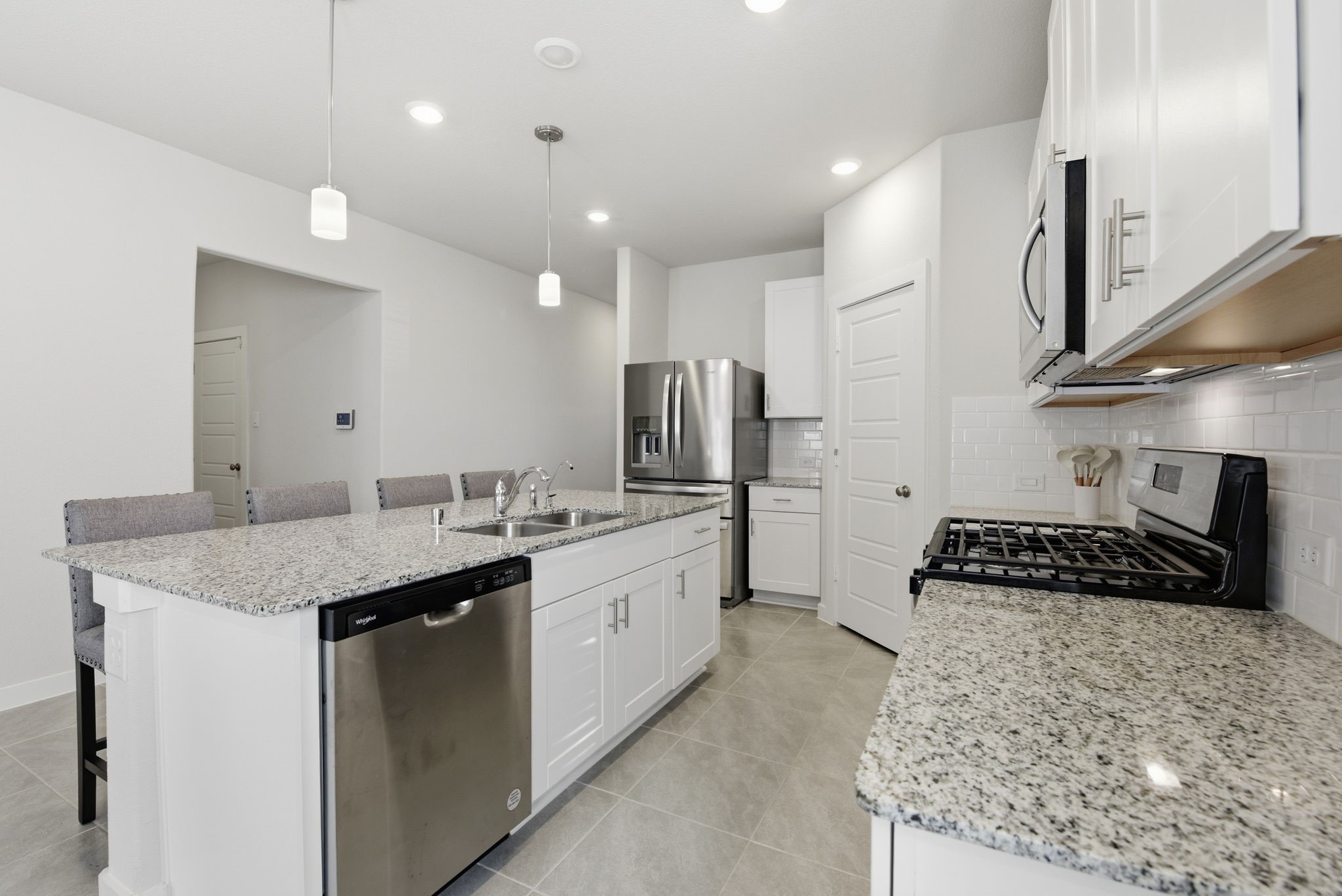 18623 Frost Ridge Drive Crosby, TX 77532 - Photo 4 of 40 a kitchen with stainless steel appliances granite countertop a sink a stove and a refrigerator