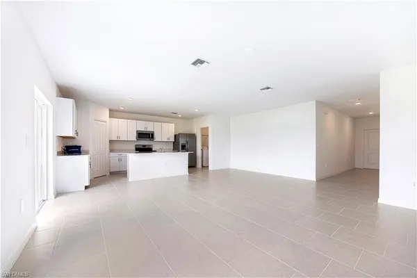 a view of kitchen with kitchen island microwave and cabinets