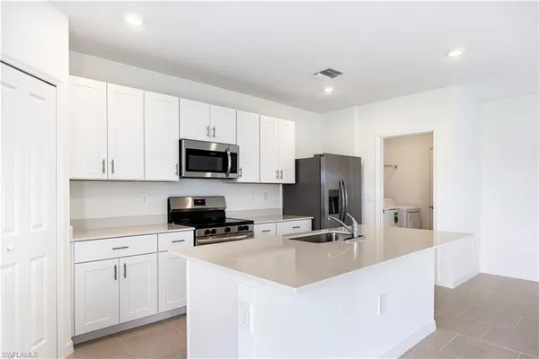 a kitchen with a sink a stove cabinets and a counter top space