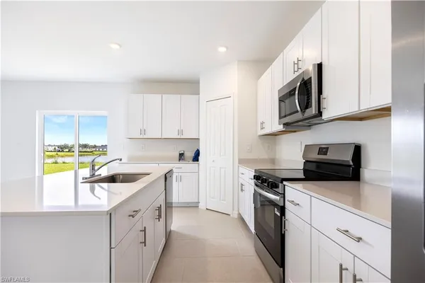 a kitchen with stainless steel appliances granite countertop a sink and a stove