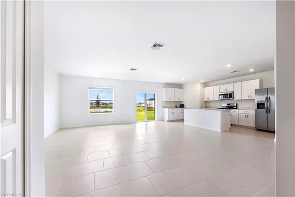a view of kitchen with stainless steel appliances kitchen island a stove and a refrigerator