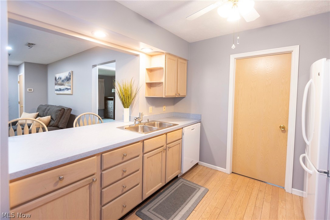 19510 Lorain Road, Unit 101 Cleveland, OH 44126 - Photo 11 of 24 Kitchen featuring light brown cabinets, white appliances, ceiling fan, light hardwood / wood-style floors, and sink
