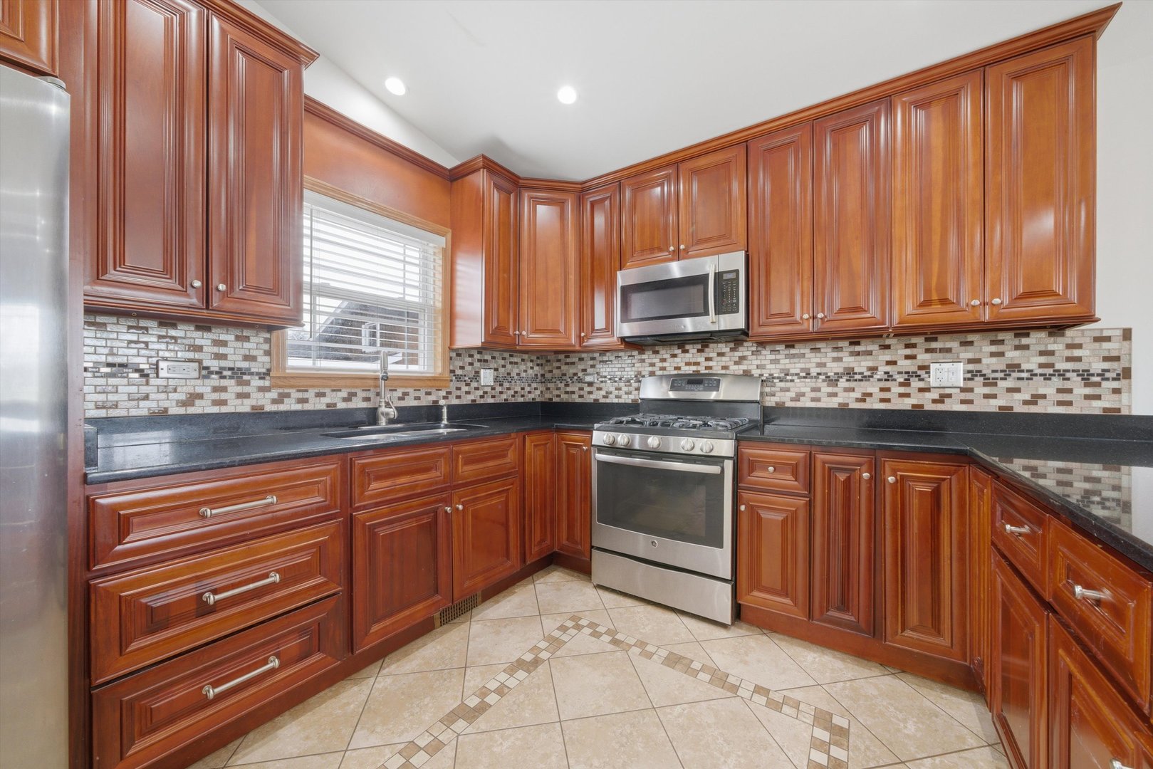10725 Rutherford Avenue Worth, IL 60482 - Photo 17 of 44 a kitchen with stainless steel appliances granite countertop wooden cabinets a stove top oven a sink and dishwasher