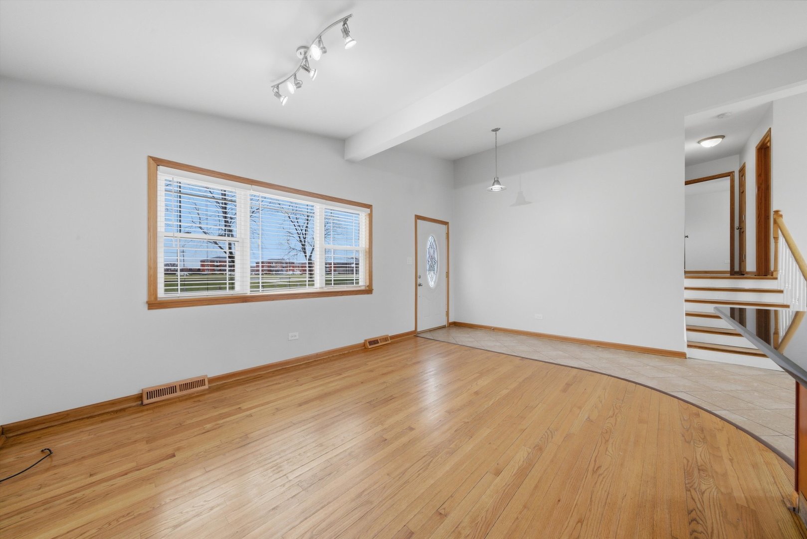 10725 Rutherford Avenue Worth, IL 60482 - Photo 10 of 44 a view of an empty room with a window and wooden floor