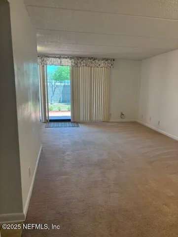 a view of a livingroom with an empty space and a window