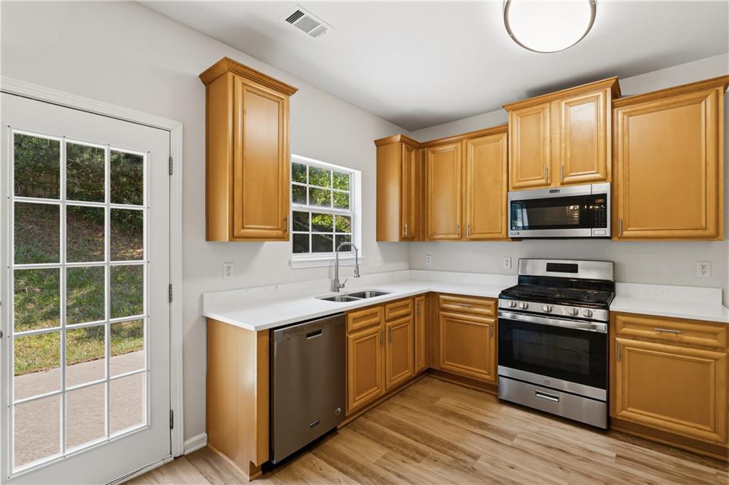 6065 Hemperly Road College Park, GA 30349 - Photo 6 of 18 a kitchen with stainless steel appliances granite countertop a stove a sink and a microwave