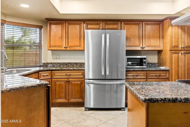 a kitchen with granite countertop a refrigerator and a sink