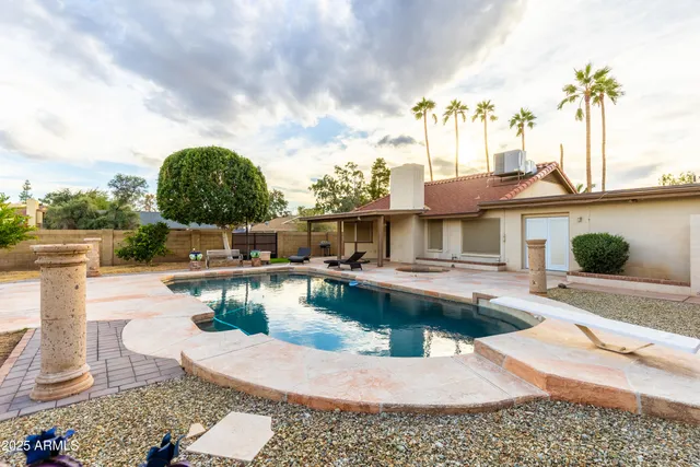 a view of a house with swimming pool and sitting area