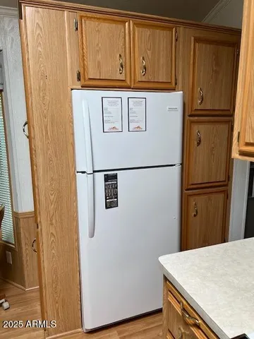 a view of a refrigerator in kitchen with stainless steel appliances wooden floor