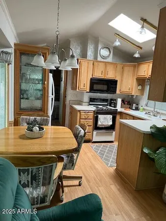 a kitchen with stainless steel appliances kitchen island granite countertop a sink a stove a dining table and chairs