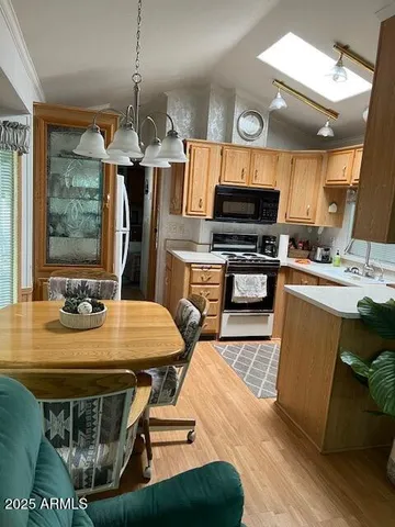 a kitchen with stainless steel appliances kitchen island granite countertop a sink a stove a dining table and chairs