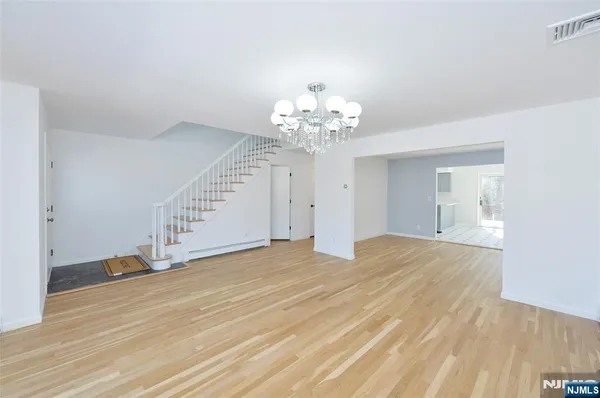 a view of a livingroom with wooden floor and stairs