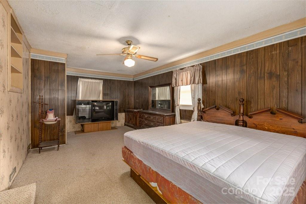 489 Ned Mcgimsey Road Nebo, NC 28761 - Photo 13 of 25 a spacious bedroom with a large bed a flat tv screen and a dresser